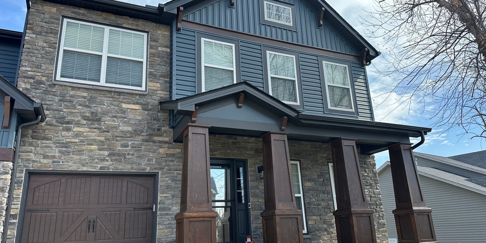 A craftsman-style St. Louis home with new board-and-batten and stone siding installed by Reliant Exteriors